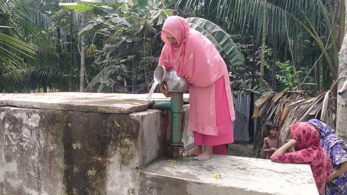 বিশুদ্ধ পানি পেতে ফিল্টারে পানি ঢালছেন স্থানীয় এক গৃহবধূ